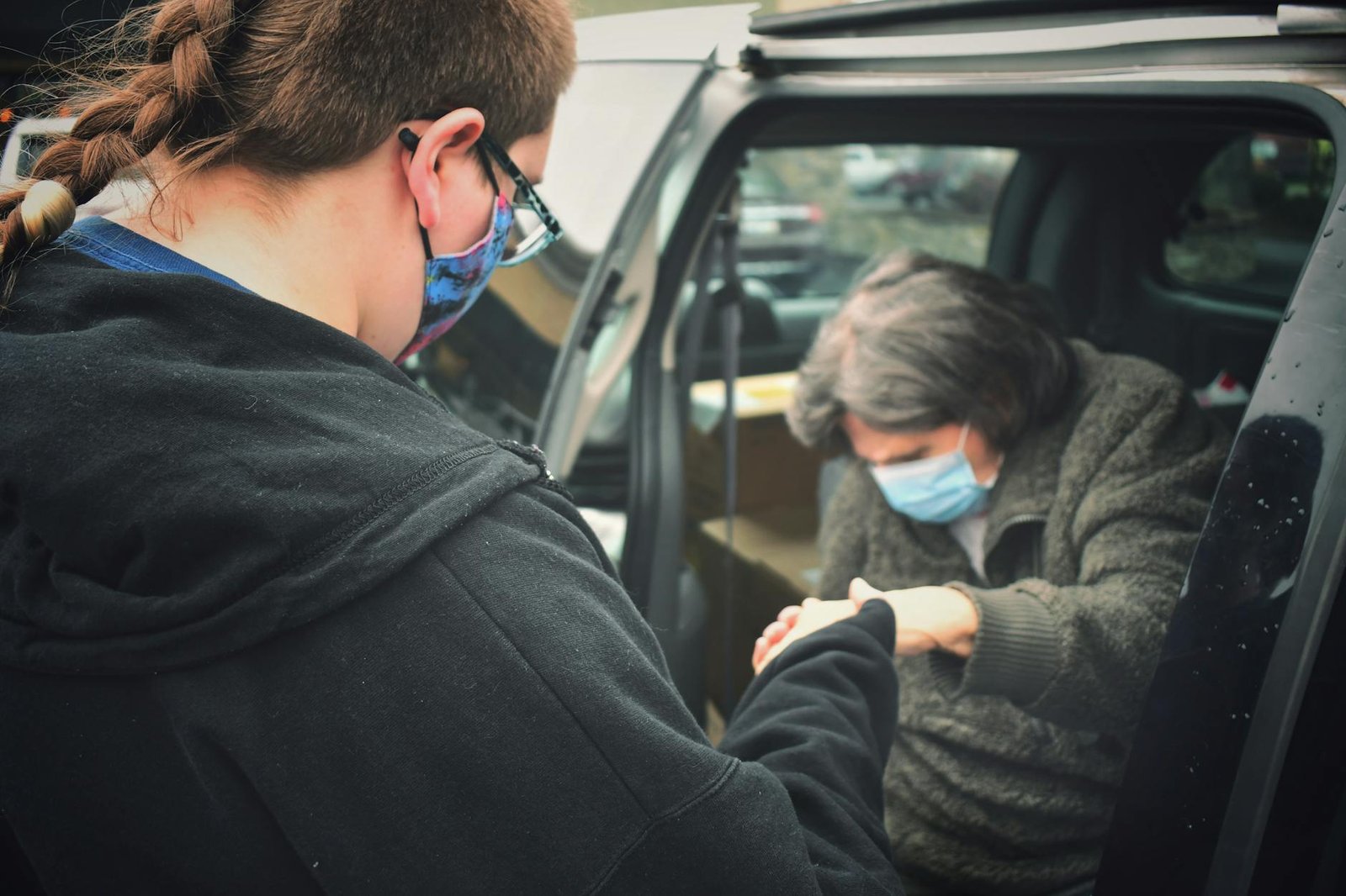 person in black jacket assisting a woman